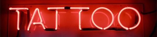 Red neon "Tattoo" sign glowing brightly.