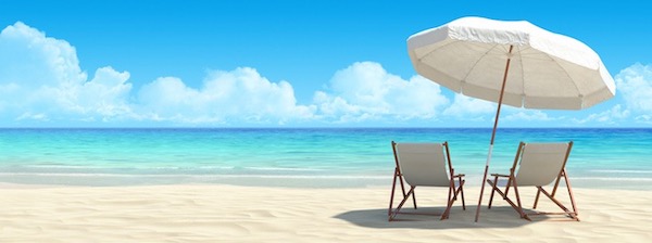 Two beach chairs under umbrella by ocean.