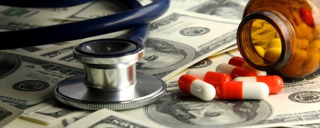 Stethoscope, pills, and money on table.