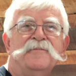 Man with glasses and large white mustache.