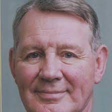 Smiling man with short, gray hair.