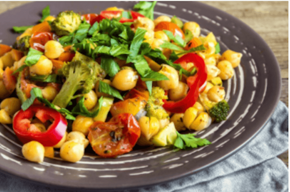 Chickpea salad with vegetables on plate.