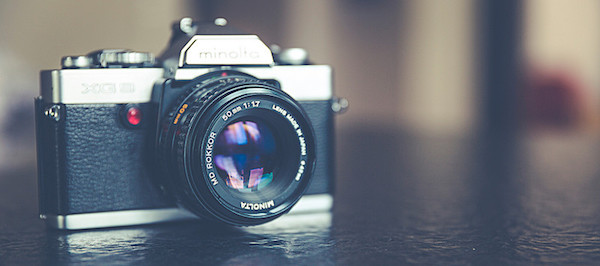 Vintage camera on a dark reflective surface.