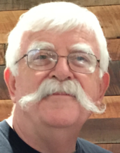 Man with white mustache and glasses.