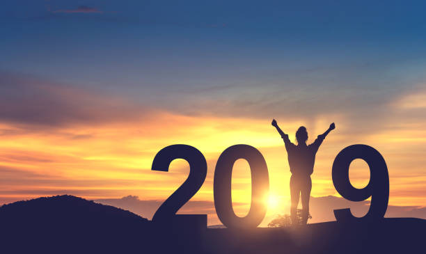 Silhouette with 2019 at sunset background.