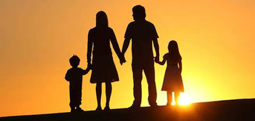 Family silhouette at sunset holding hands.