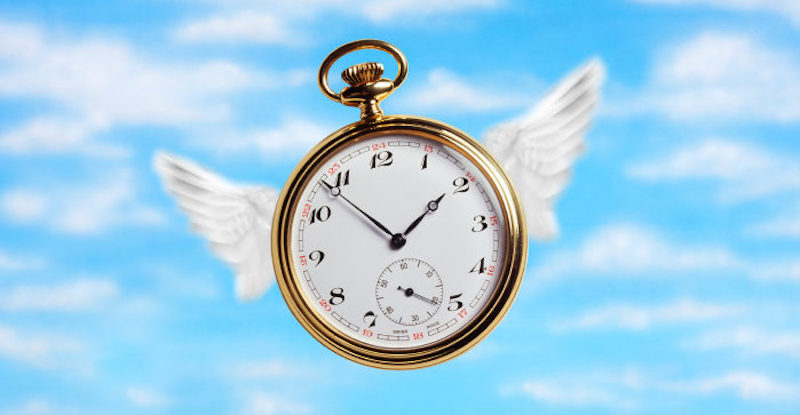 Pocket watch with wings on cloudy sky.