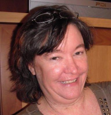 Smiling woman with glasses on her head.