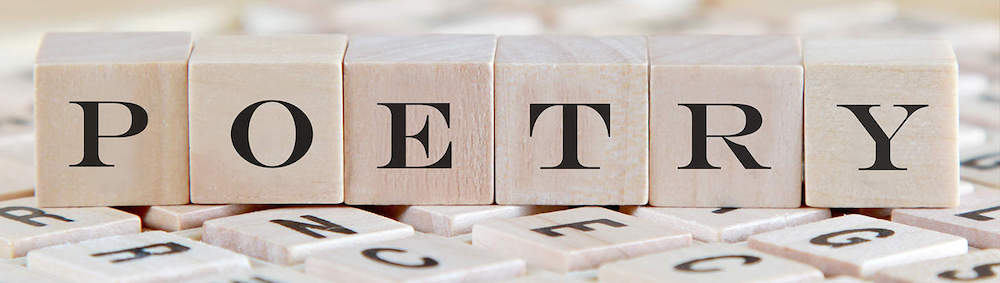 Wooden blocks spelling "POETRY" on letters.