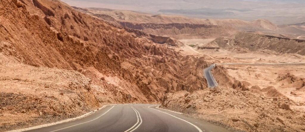 Desert road winding through rocky landscape.
