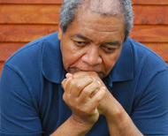 Man in deep thought, wearing blue shirt.