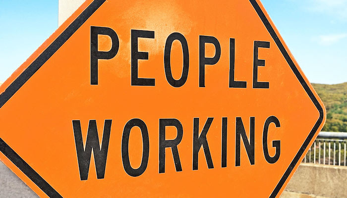 Orange "People Working" construction warning sign.