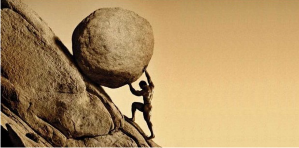Man pushing large boulder up hill.