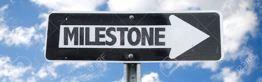 Sign with "Milestone" and arrow, cloudy sky.