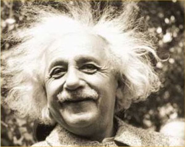 Smiling man with wild, white hair outdoors.