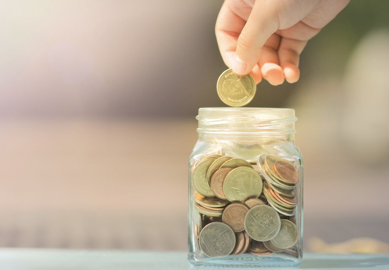 A person putting money in a jar