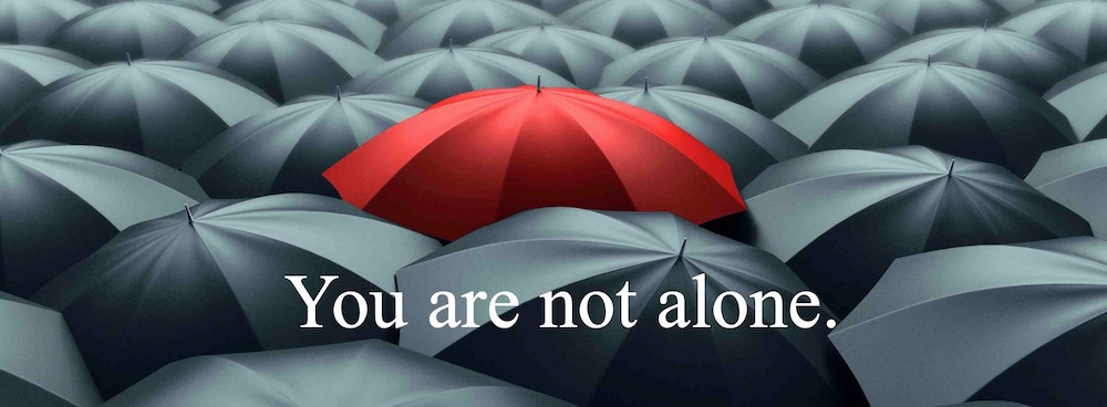 Red umbrella among black umbrellas, inspirational message.